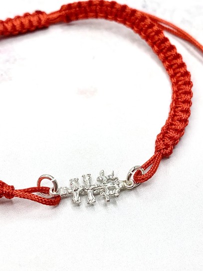 Red Caravaca Cross bracelet made of macramé and silver